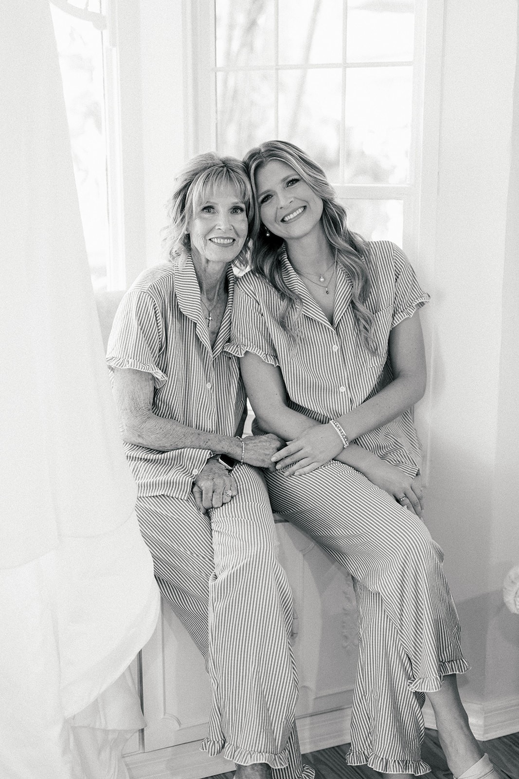 Chellsea and her mother cuddled together in matching striped pajamas by a window