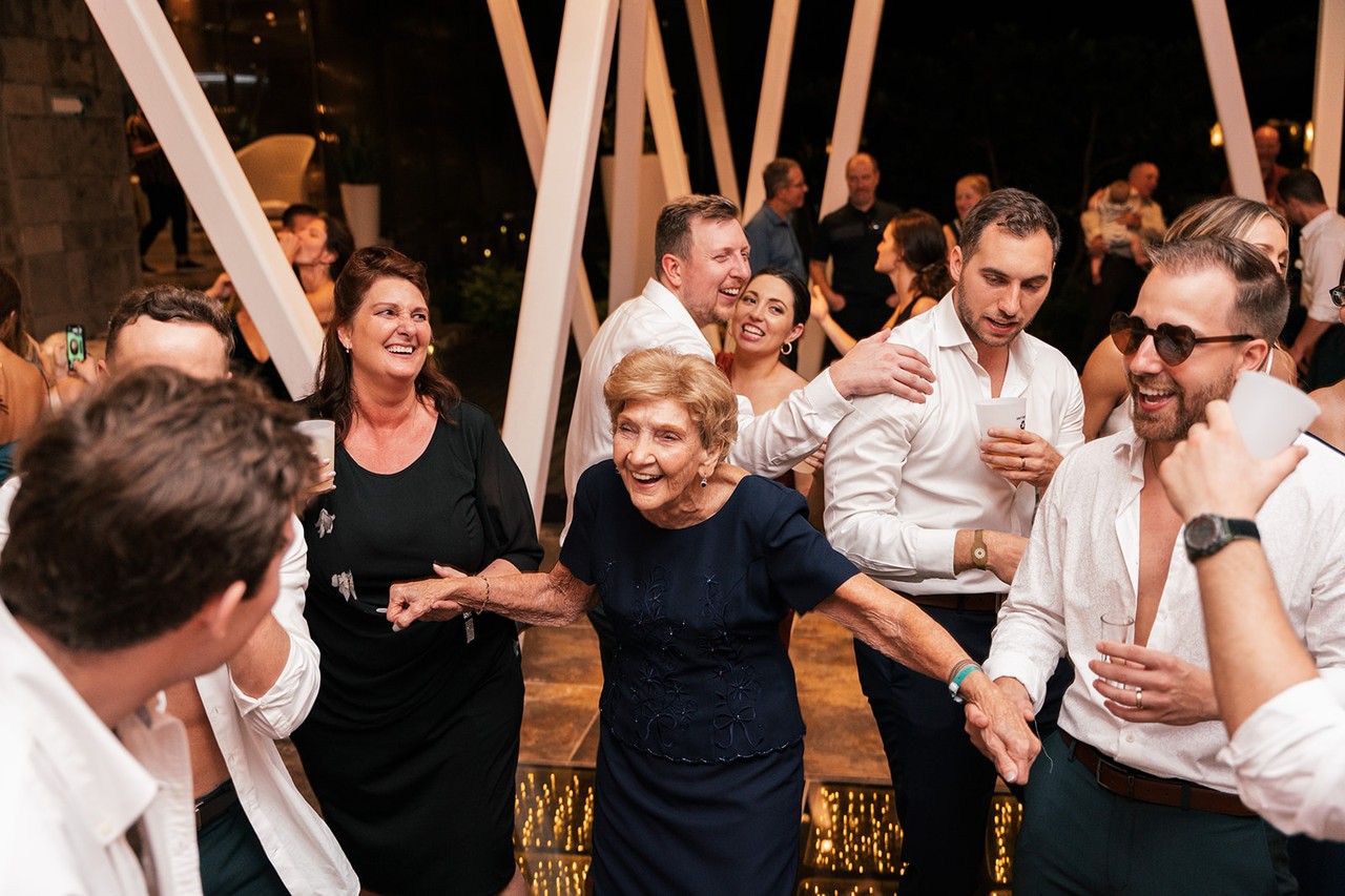 Guests laughing and dancing closely together at the lively evening reception