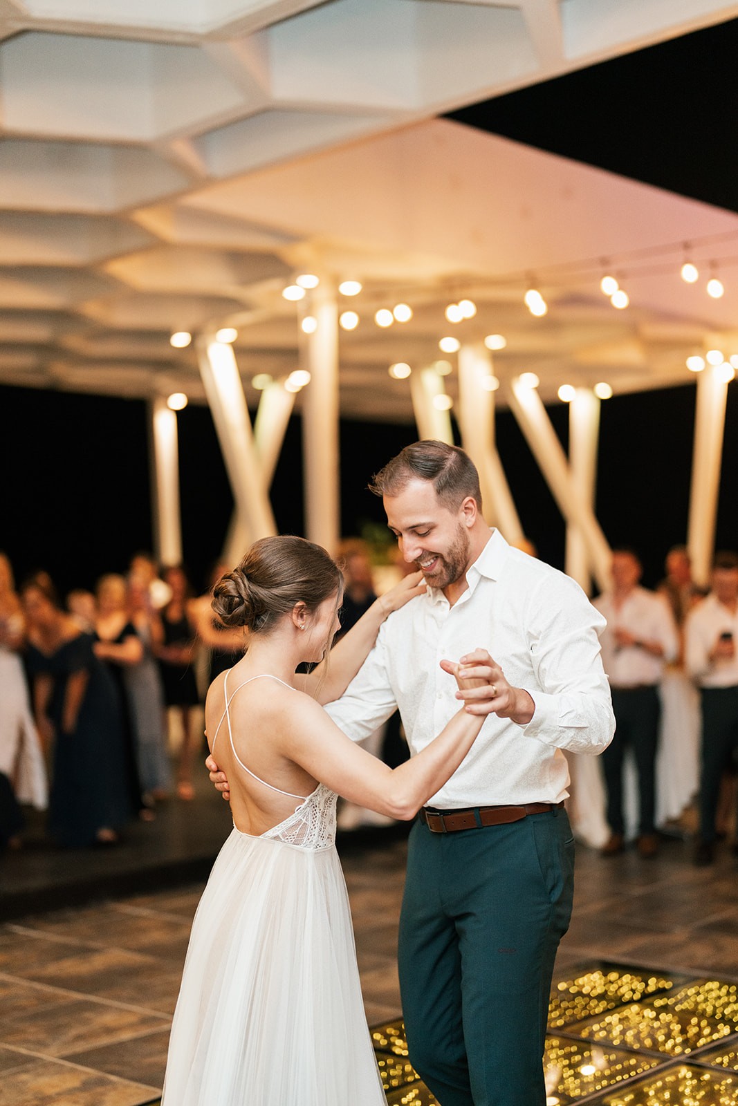 Lindsey and Brian sharing their first dance under string lights at the reception