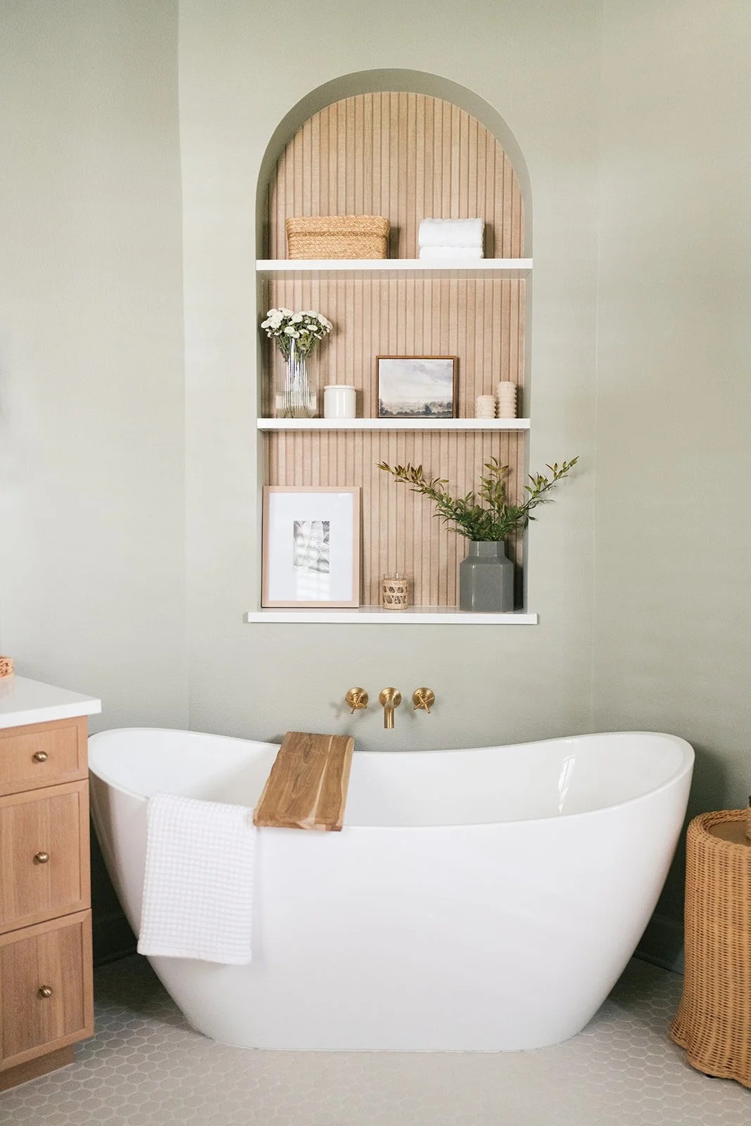 Modern bathroom with white freestanding bathtub and decorative shelving