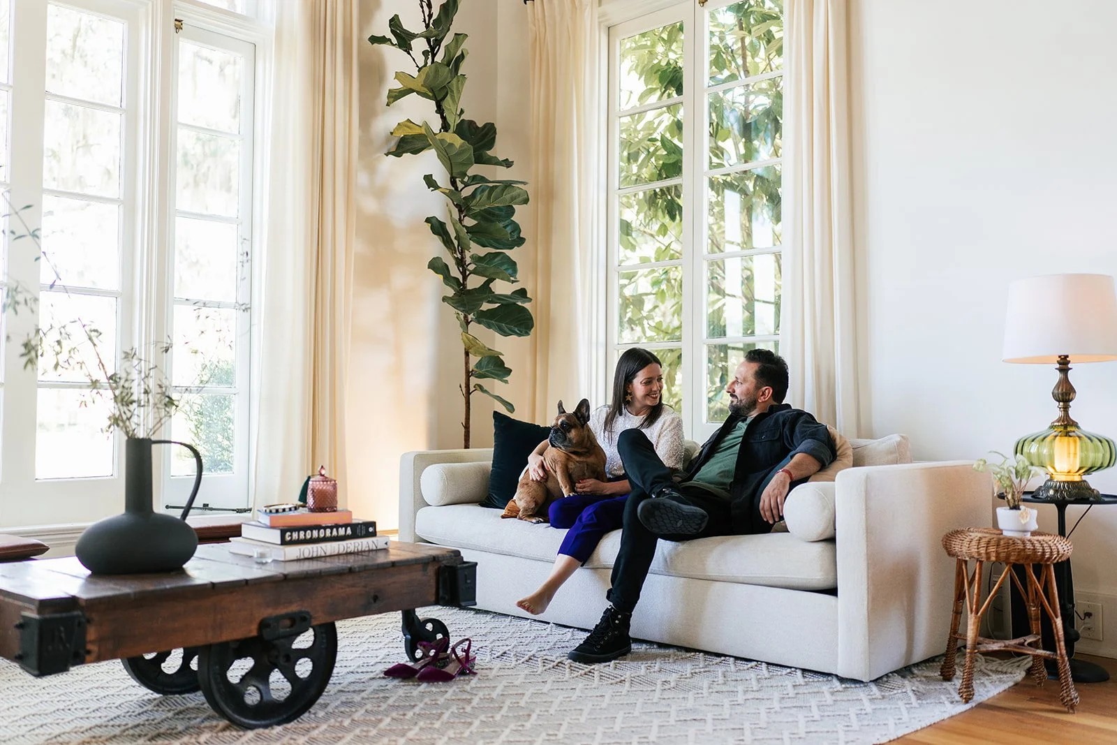 Couple seated on a white sofa in a bright living room