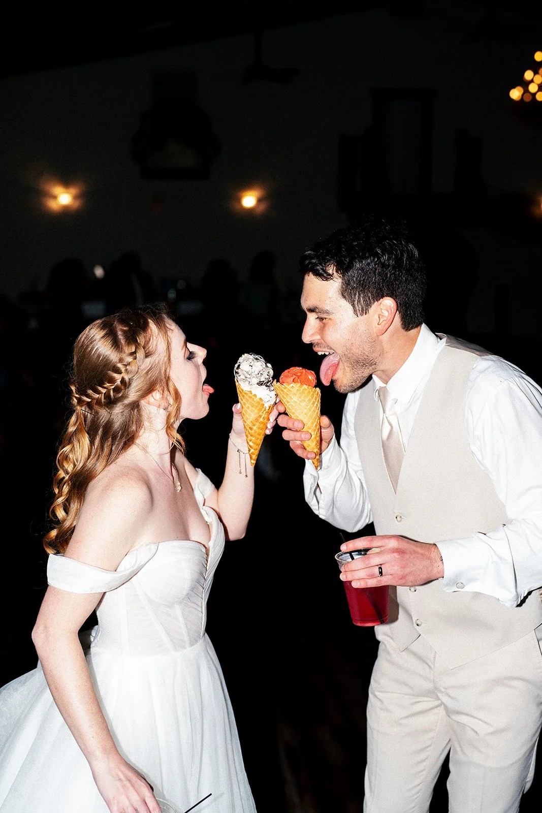 Bride and groom share ice cream cones and laugh together at their reception