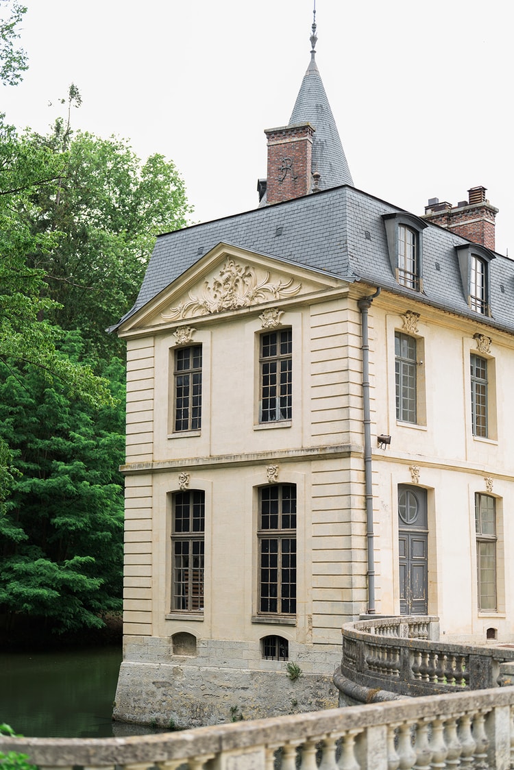 Wrought-iron gate and lantern opening onto the turreted pavilion of Domaine du Château d'Ermenonville