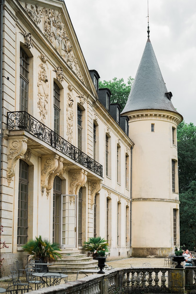 Carved facade and fairy-tale tower of Domaine du Chateau d'Ermenonville, iron balcony above the terrace doors