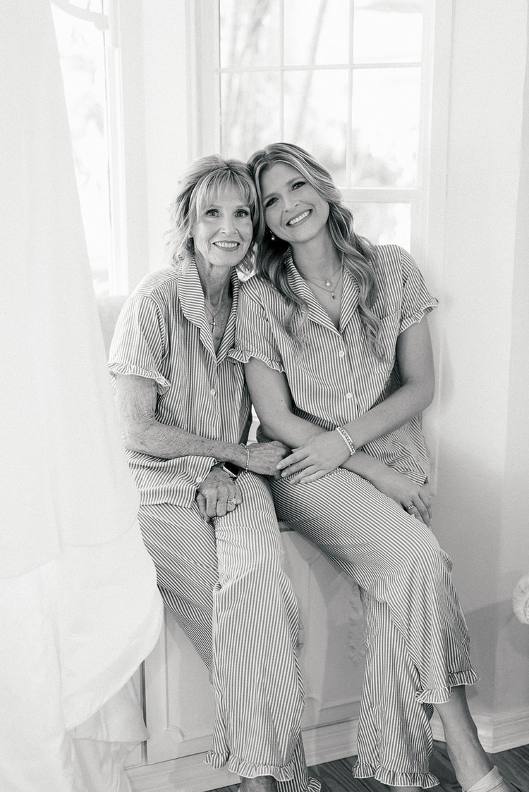 Chellsea and her mother cuddled together in matching striped pajamas by a window