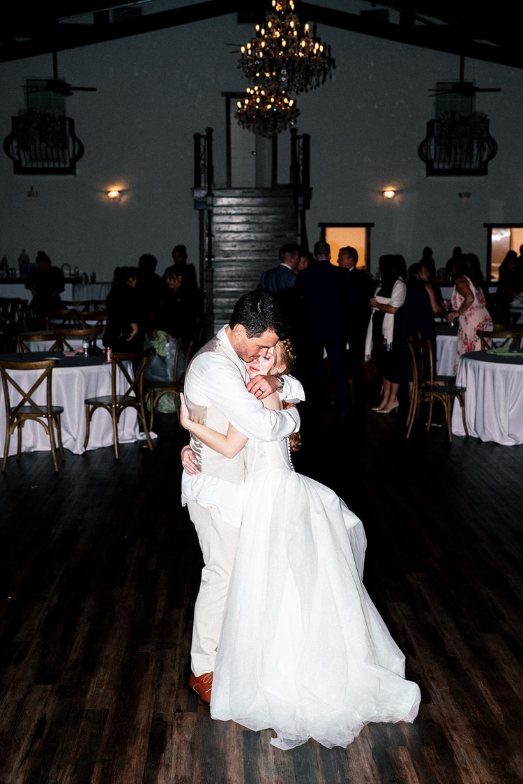 Groom dips his bride for a kiss as guests wave lit sparklers to send the couple off after their Orlando reception.
