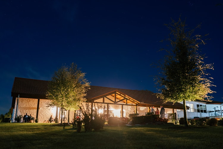 Nighttime view of the Orlando venue's covered porch and gabled roofline glowing under uplit trees and a starry sky.