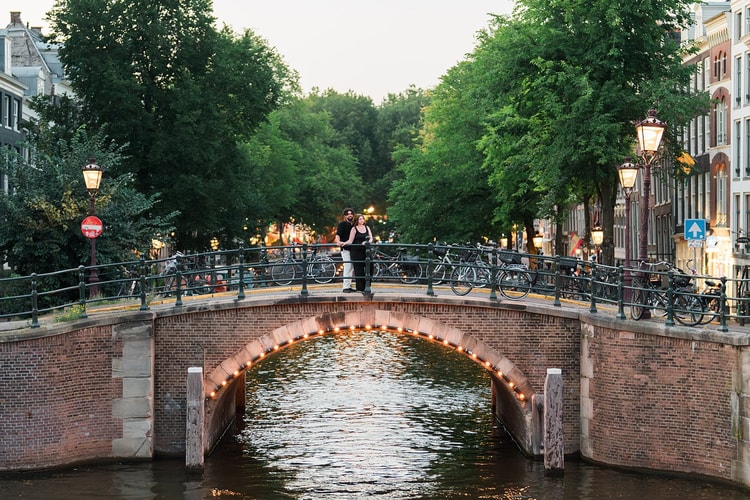 Low-light Amsterdam couple portrait at dusk. Low light, easy presence.
